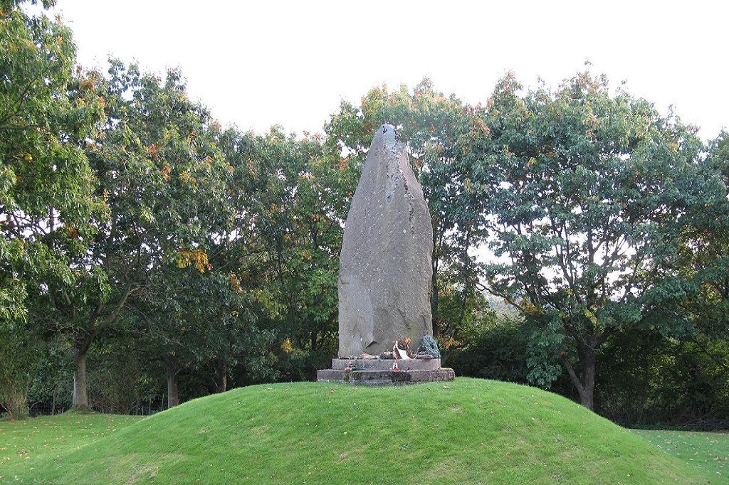 Cilmeri stone memorial. Statue on a grassy mound with trees in the background