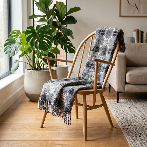 Senedd Welsh Blanket. Draped on a wooden chair in a modern living room