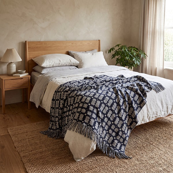 Bodnant Welsh Blanket. Draped over a double bed in a modern bedroom