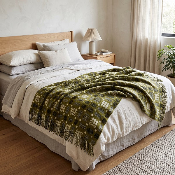 Cwm Elan Welsh blanket. Draped over a double bed in a modern bedroom.