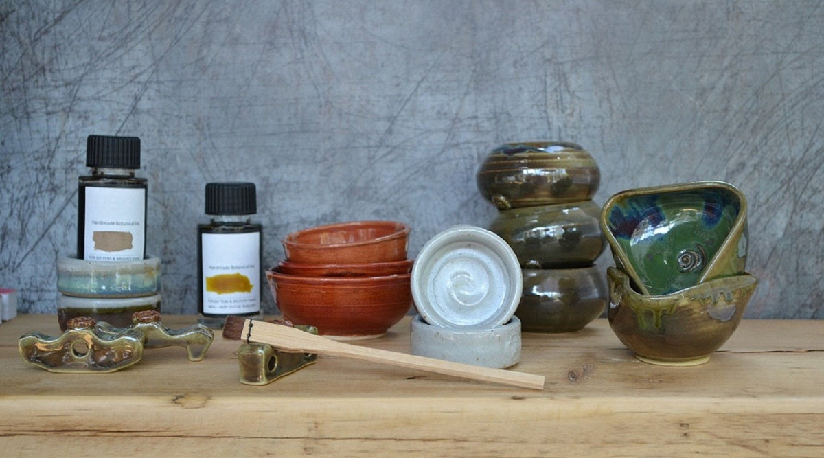 Inkwells, water bowls and pen stands are hand thrown to the TirGlas design. Glazed in greens, blues, browns and golds, each has a turned foot ring