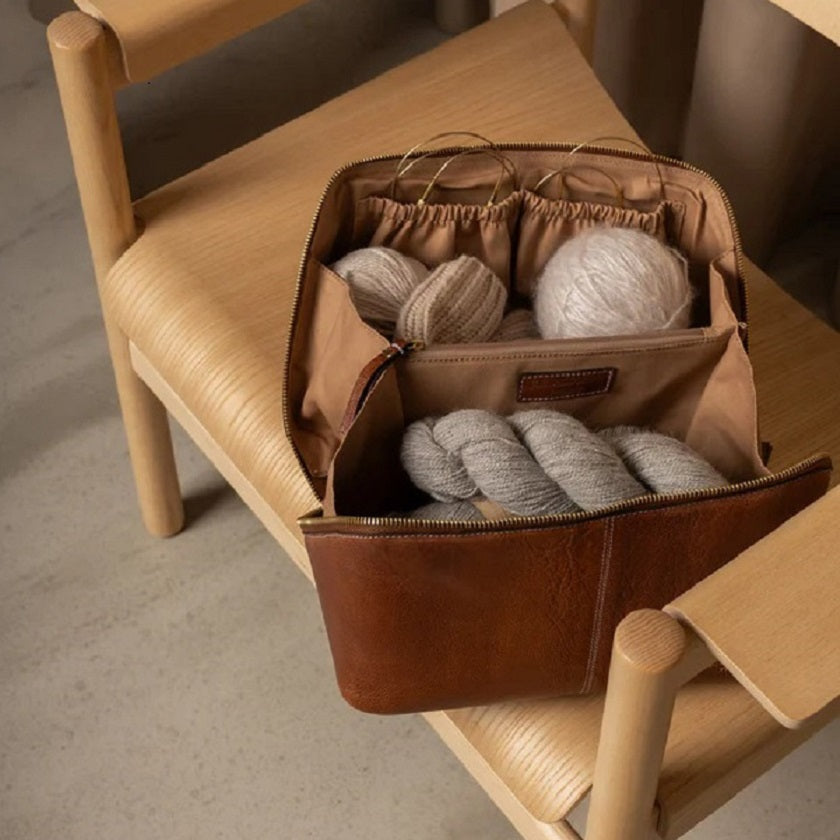 ReDesigned Project 10 - Brown leather bag with yarn on a wooden chair