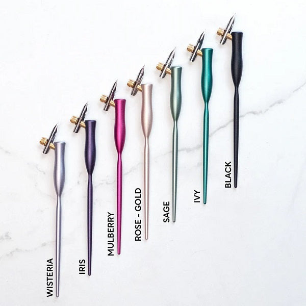 Toms Studios Flourish Oblique Calligraphy Pens - Set of colourful fountain pens on a marble surface with colour labels.