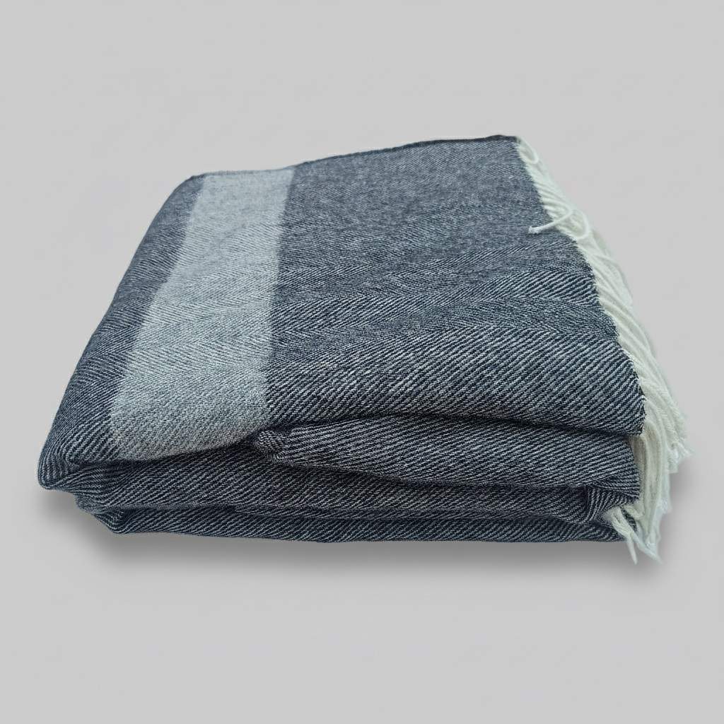 Welsh blanket, Pembroke. Folded grey herringbone striped blanket with off white fringe edges