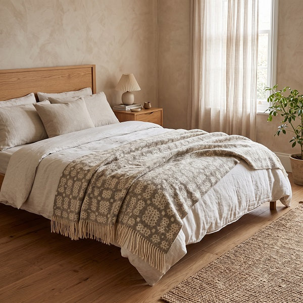 Garreg Ddu Welsh blanket. Draped over a double bed in a modern bedroom.