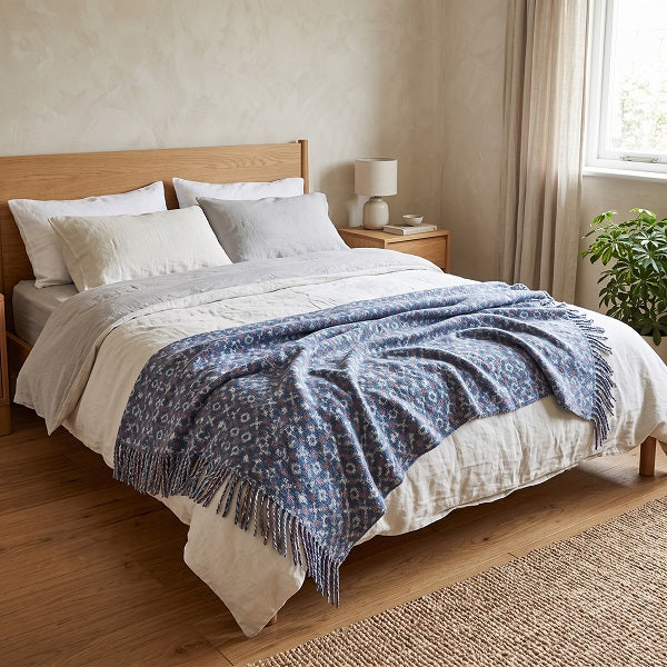 Pen y Fan Welsh blanket. Draped over a double bed in a modern bedroom.