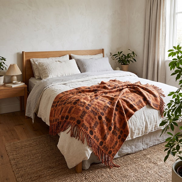 Pierhead Welsh blanket. Draped over a double bed in a modern bedroom.