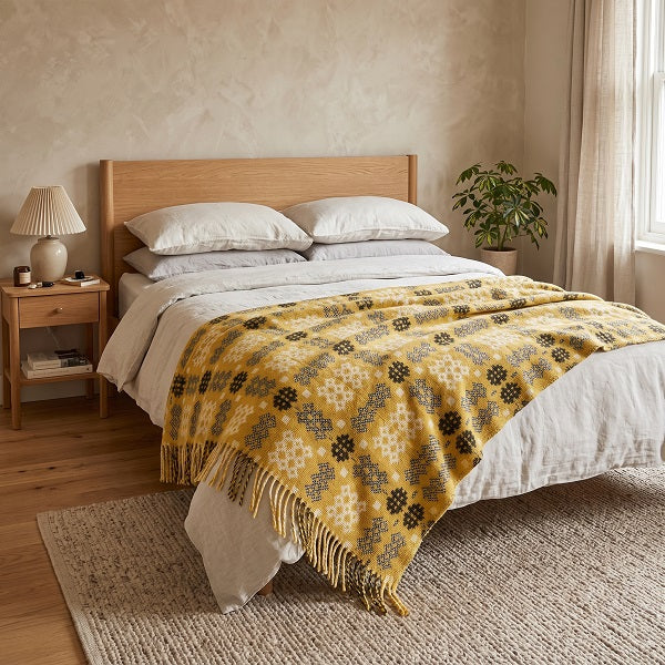Rhonda Welsh blanket. Draped over a double bed in a modern bedroom.