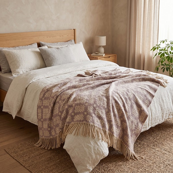 Rhosili Welsh blanket. Draped over a double bed in a modern bedroom.