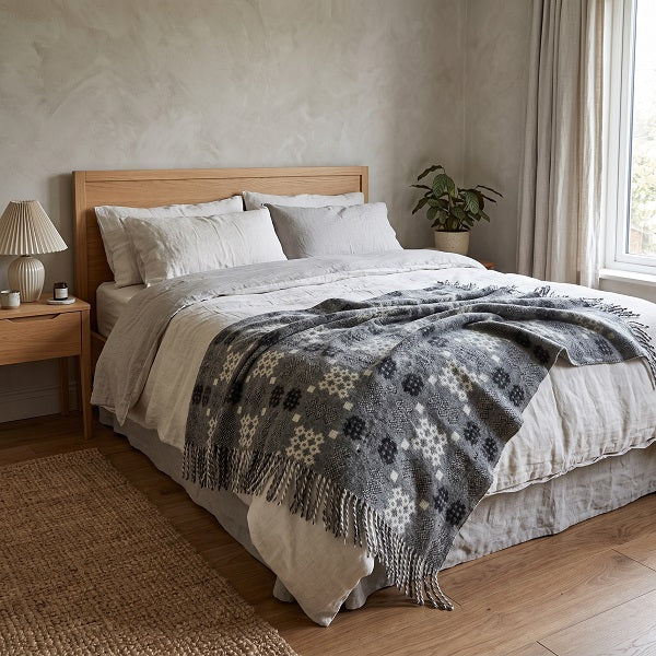 Senedd Welsh blanket. Draped over a double bed in a modern bedroom.