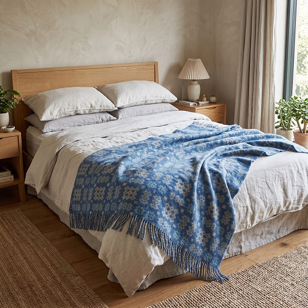 St Davids Welsh blanket. Draped over a double bed in a modern bedroom.