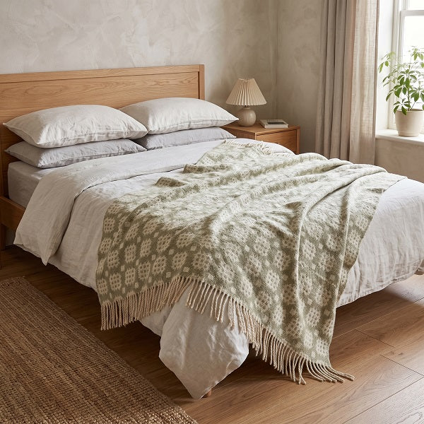 St Donats Welsh blanket. Draped over a double bed in a modern bedroom.