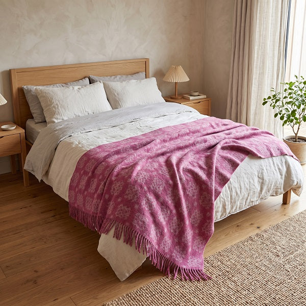 Ynys Mon Welsh blanket. Draped over a double bed in a modern bedroom.