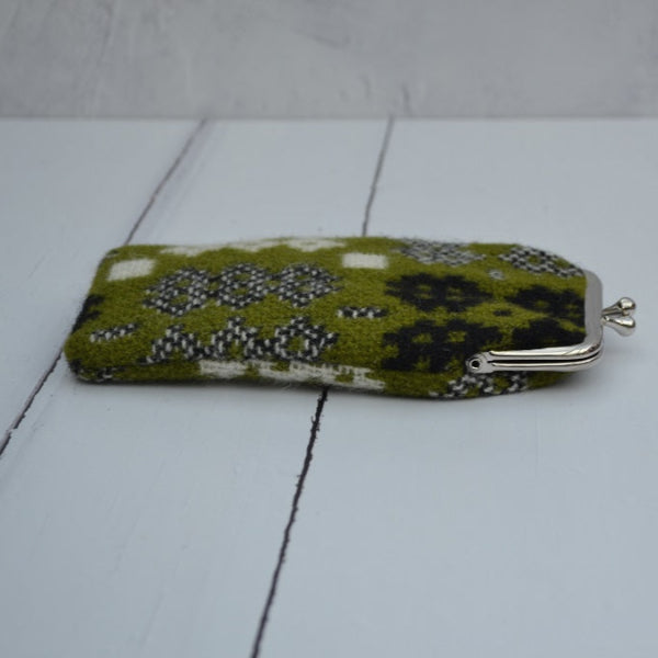 A collection of Welsh tapestry eye glasses cases with metal clasp, displayed on a white surface. The cases feature various traditional Welsh patterns and colours.