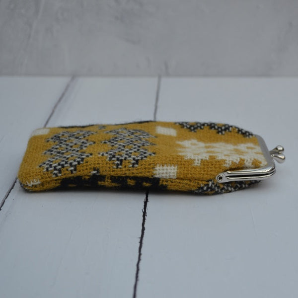 A collection of Welsh tapestry eye glasses cases with metal clasp, displayed on a white surface. The cases feature various traditional Welsh patterns and colours   .....