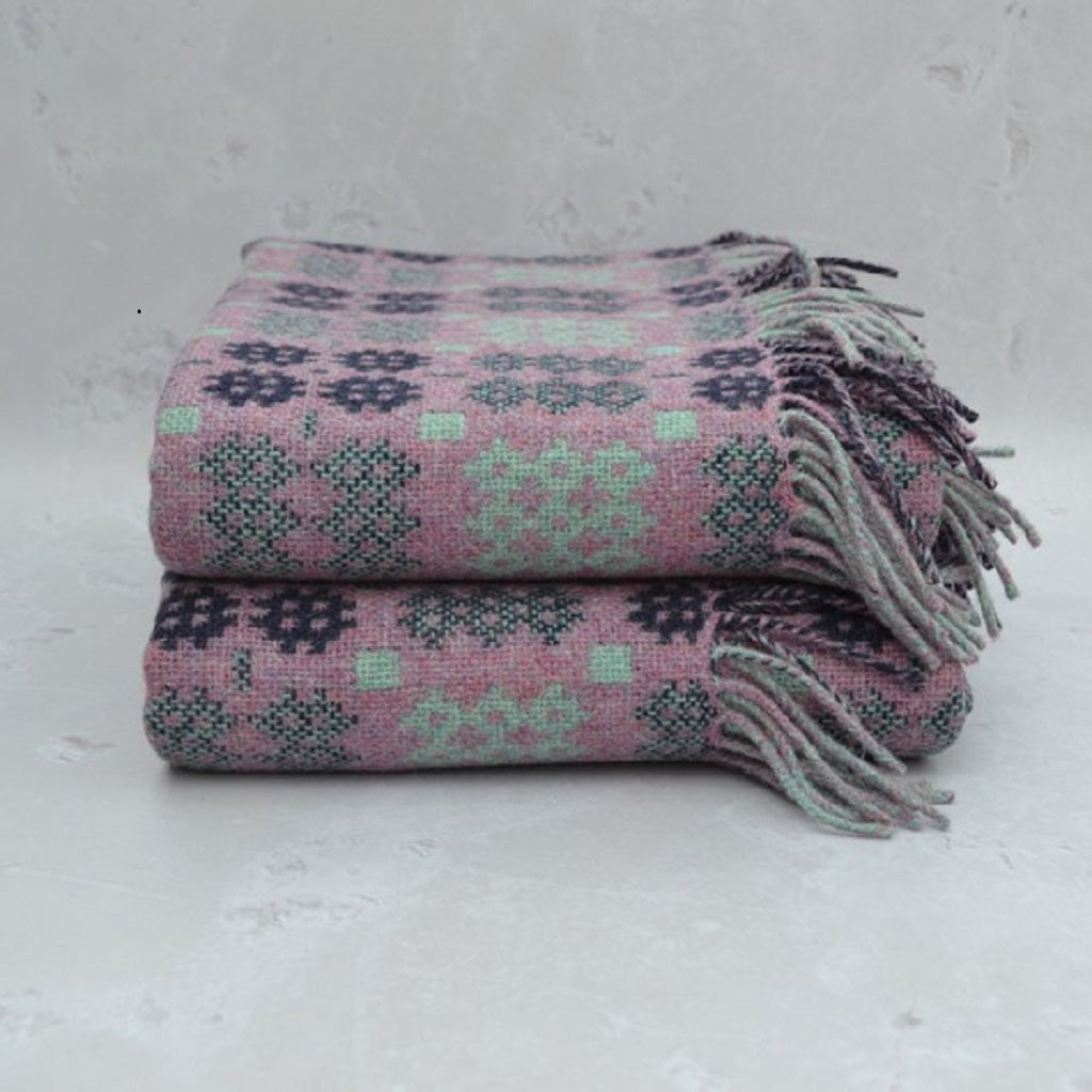 TirGlas Welsh Blankets - Cambrian  in Heather, Mint and dark navy in the Caernarfon portcullis patterns. This tapestry style blanket is the perfect blend of tradition, quality, and modern style for any room in your home. Double cloth weaving produces fully reversible blankets