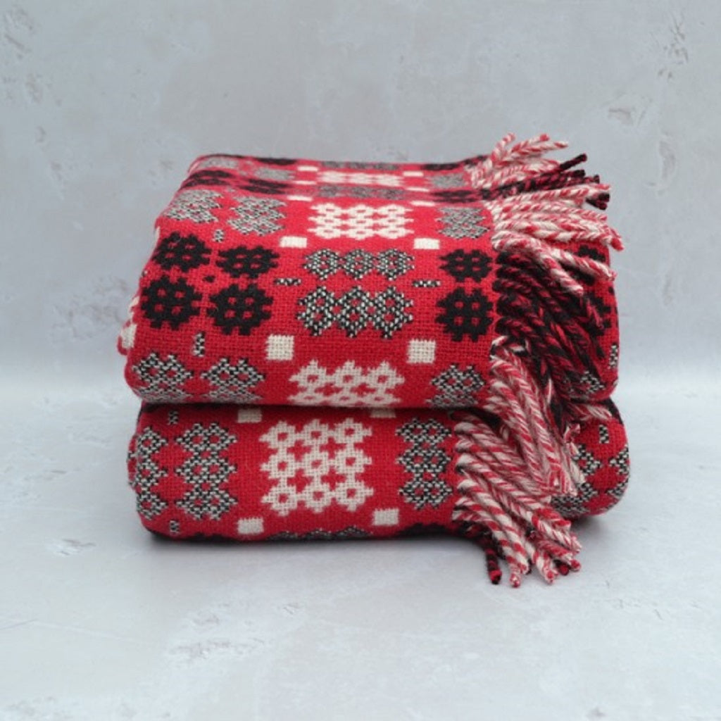 TirGlas Welsh Blankets - Draig Goch in Red Dragon Red colours with white and black in the Caernarfon portcullis patterns. This tapestry style blanket is the perfect blend of tradition, quality, and modern style for any room in your home. Double cloth weaving produced full reversible blankets