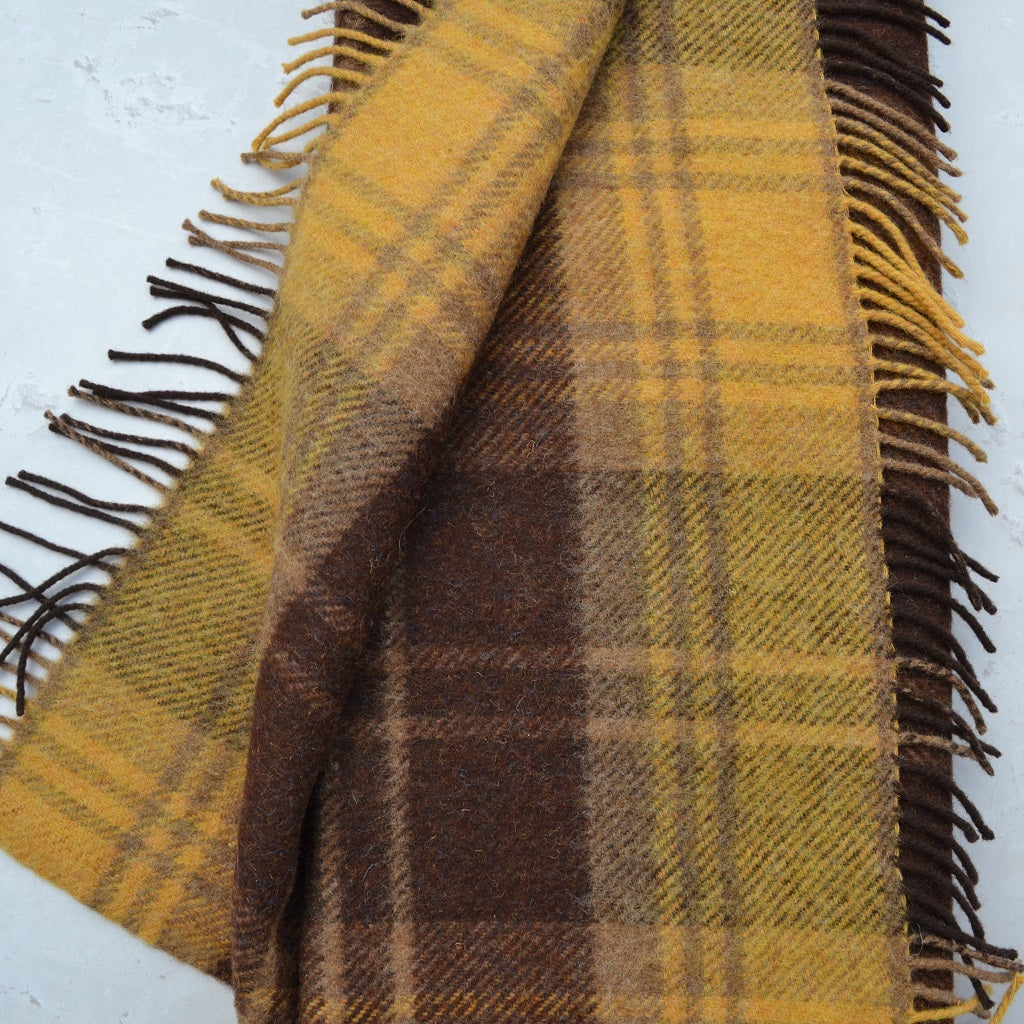 Plaid blanket with brown and yellow colors on a white background