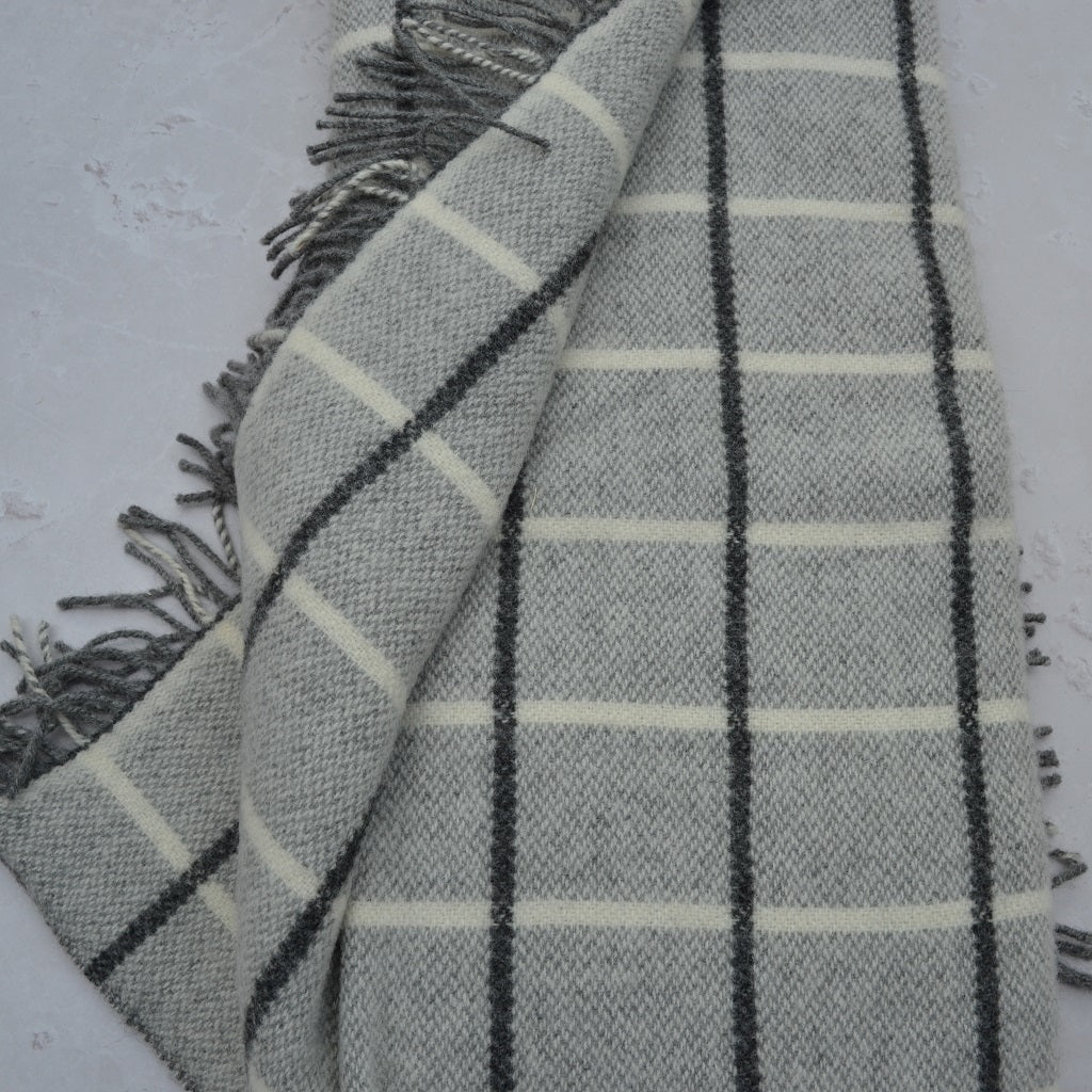 TirGlas Welsh blanket - Frenni. Soft to touch in grey with a charcoal window pane pattern.