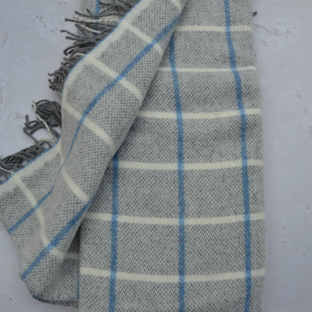 TirGlas Welsh blanket - Frenni. Soft to touch in grey with a sky blue window pane pattern