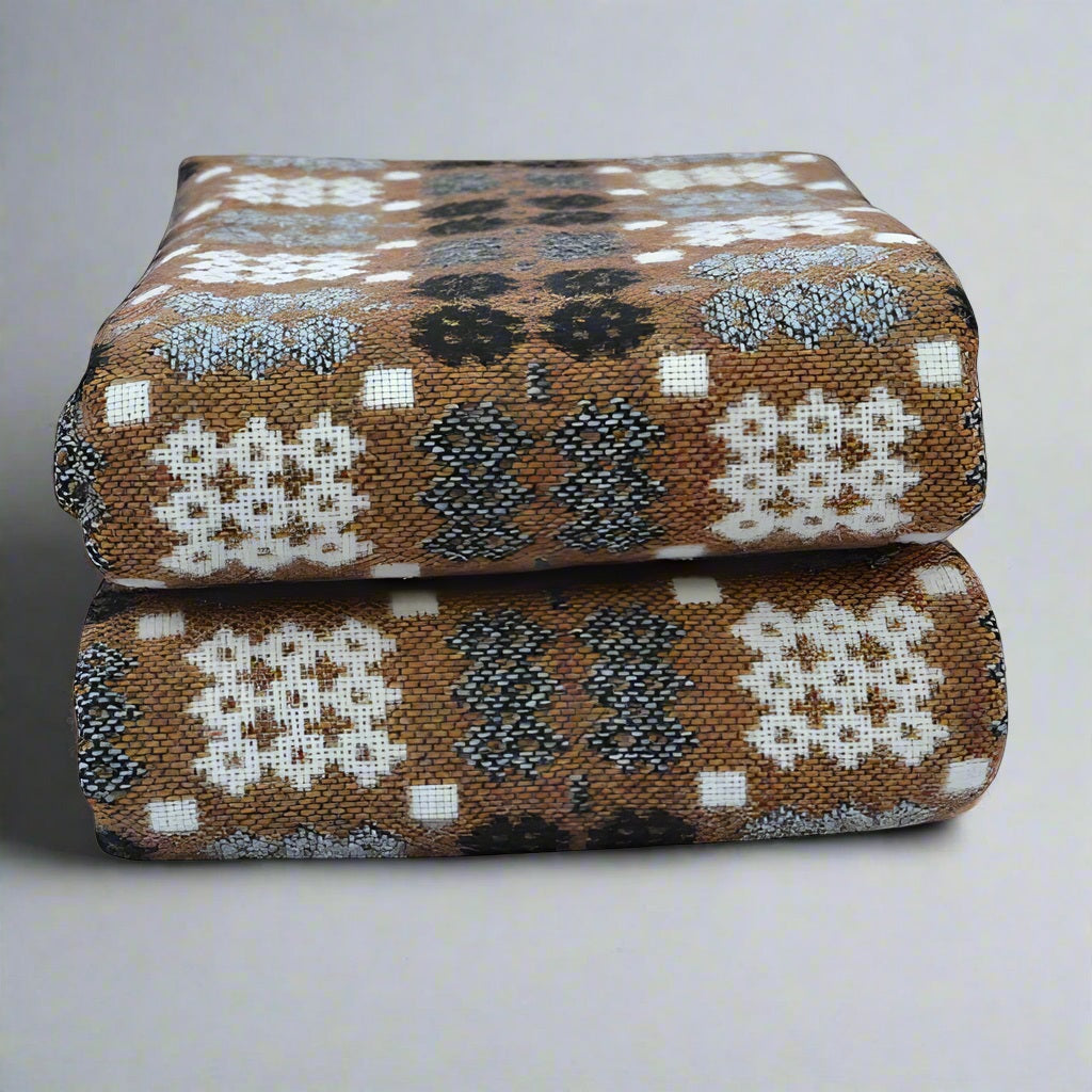 Two patterned cushions stacked on a light gray background