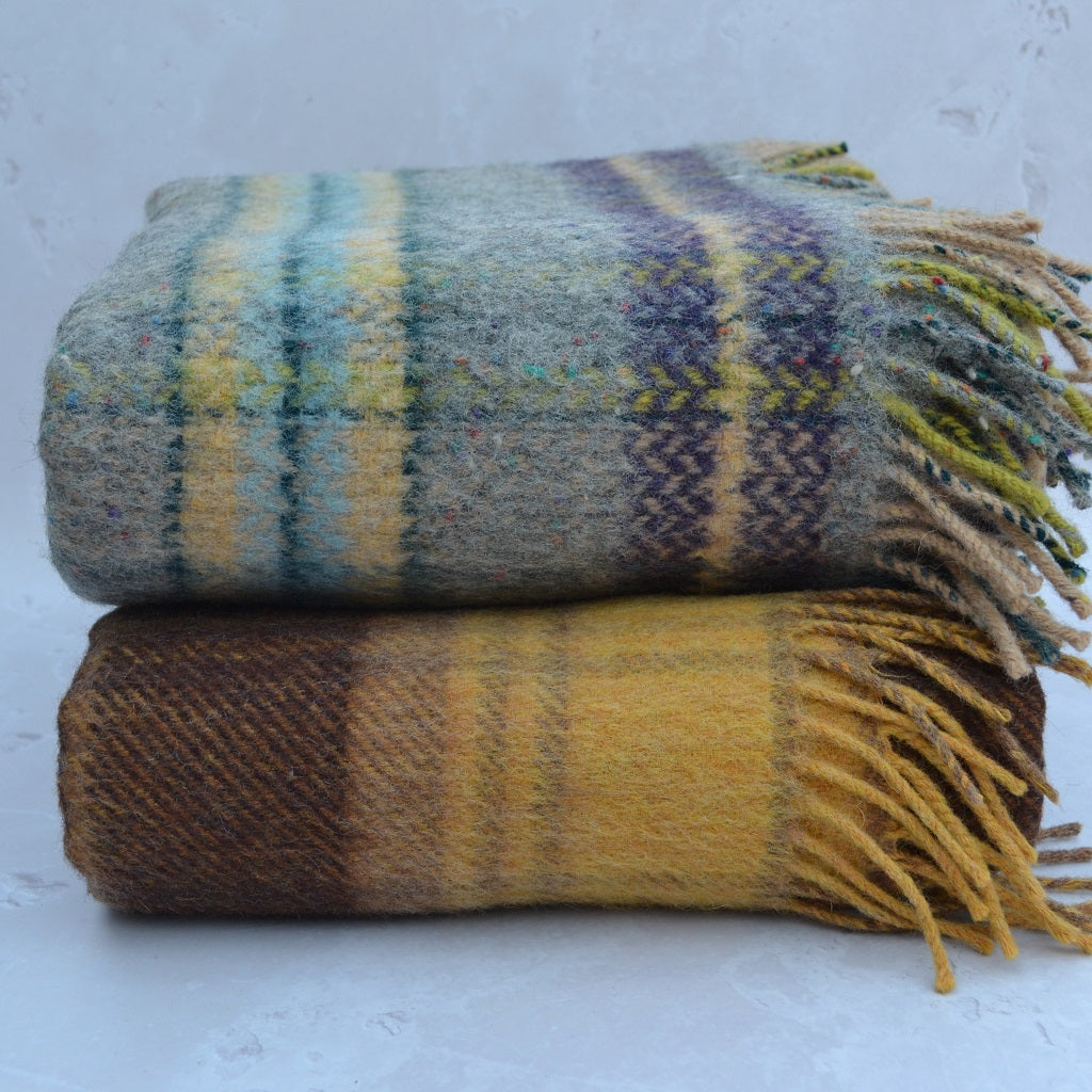Welsh blankets - Two plaid blankets stacked on a light grey background