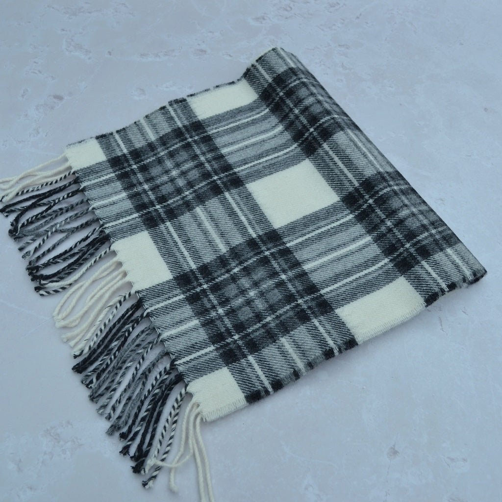 Plaid scarf with tassels on a light gray background