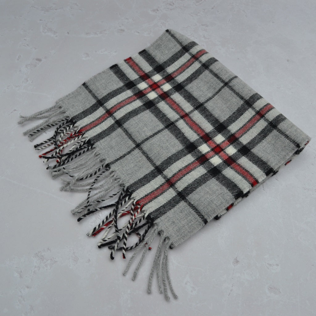 Plaid scarf with fringes on a light gray background